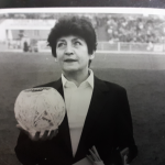 Zdjęcie czarno-białe. Sędzia żużlowa Irena Nadolna-Szatyłowska na stadionie. Trzyma puchar.